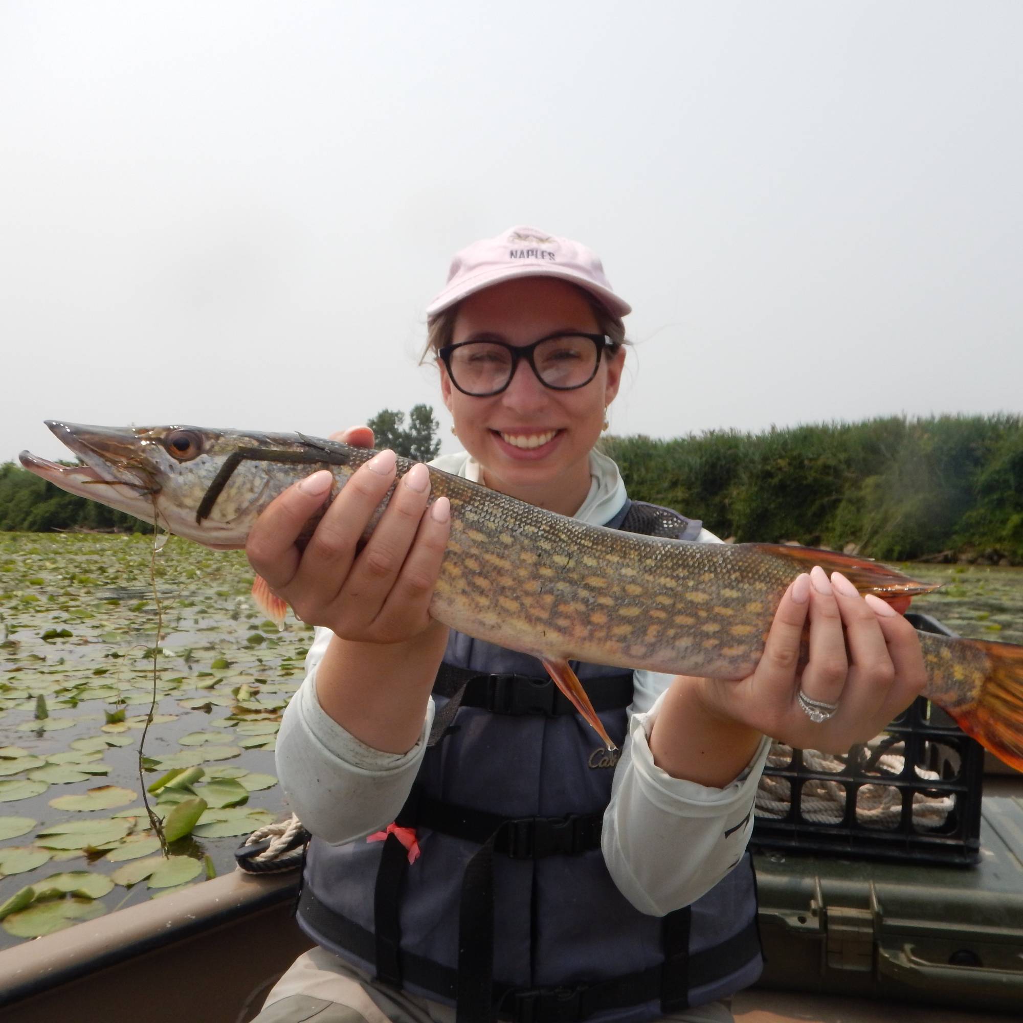 a student holds a northern pike